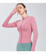 Pink women's yoga sports top with a zip-up front and long sleeves. Designed for flexibility and moisture-wicking performance.