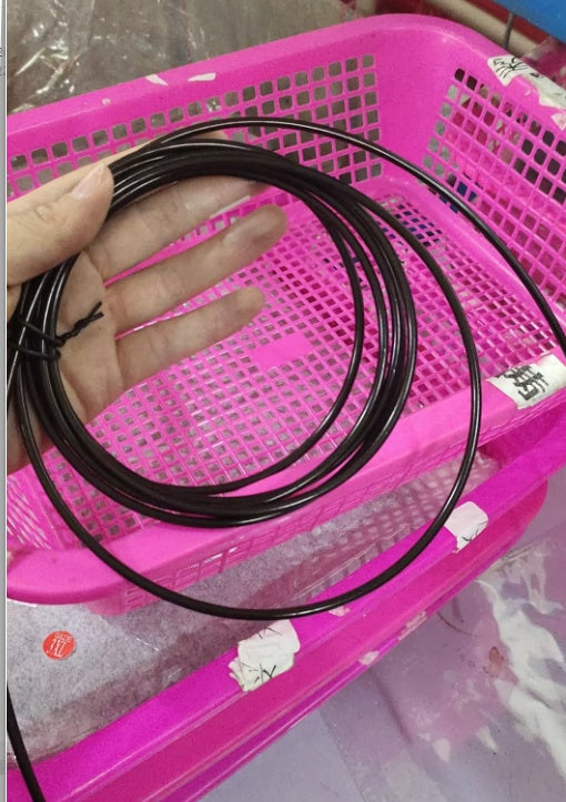 Coiled black jump rope cable held in hand. Durable and adjustable replacement cable for high-speed skipping exercises.