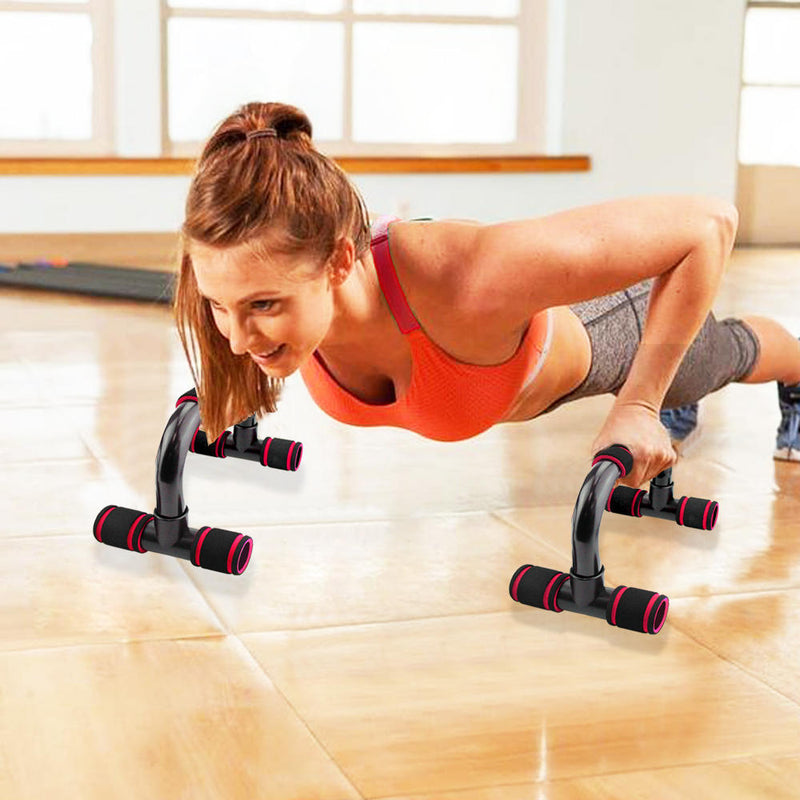 Woman using Fitness Push-Ups Stand Bars for upper body workout in a gym. Ergonomic push-up stands with padded grips for comfort and stability.