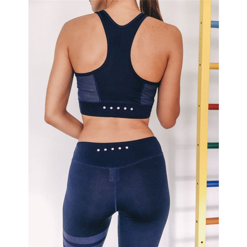 Navy blue women’s yoga set with breathable fabric and compression fit. Racerback top and high-waisted leggings for support.