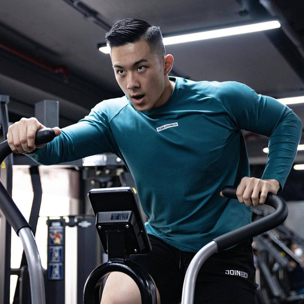 Men's fashion long sleeve sports T-shirt in teal, made from moisture-wicking polyester. Ideal for fitness workouts, available in sizes M to XXXL.