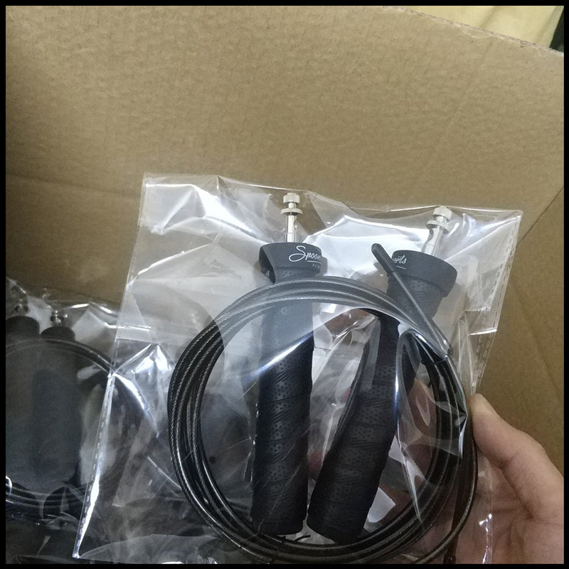 Packaged black jump rope with ergonomic handles and steel cable. Ideal for home workouts and professional training sessions.