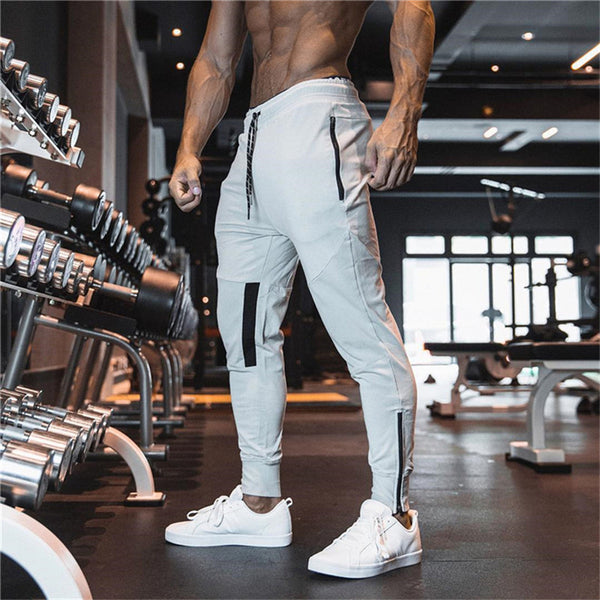 Men's sports slim pants in light gray with black accents, ideal for fitness and gym workouts. Stylish and comfortable design with ankle zippers.