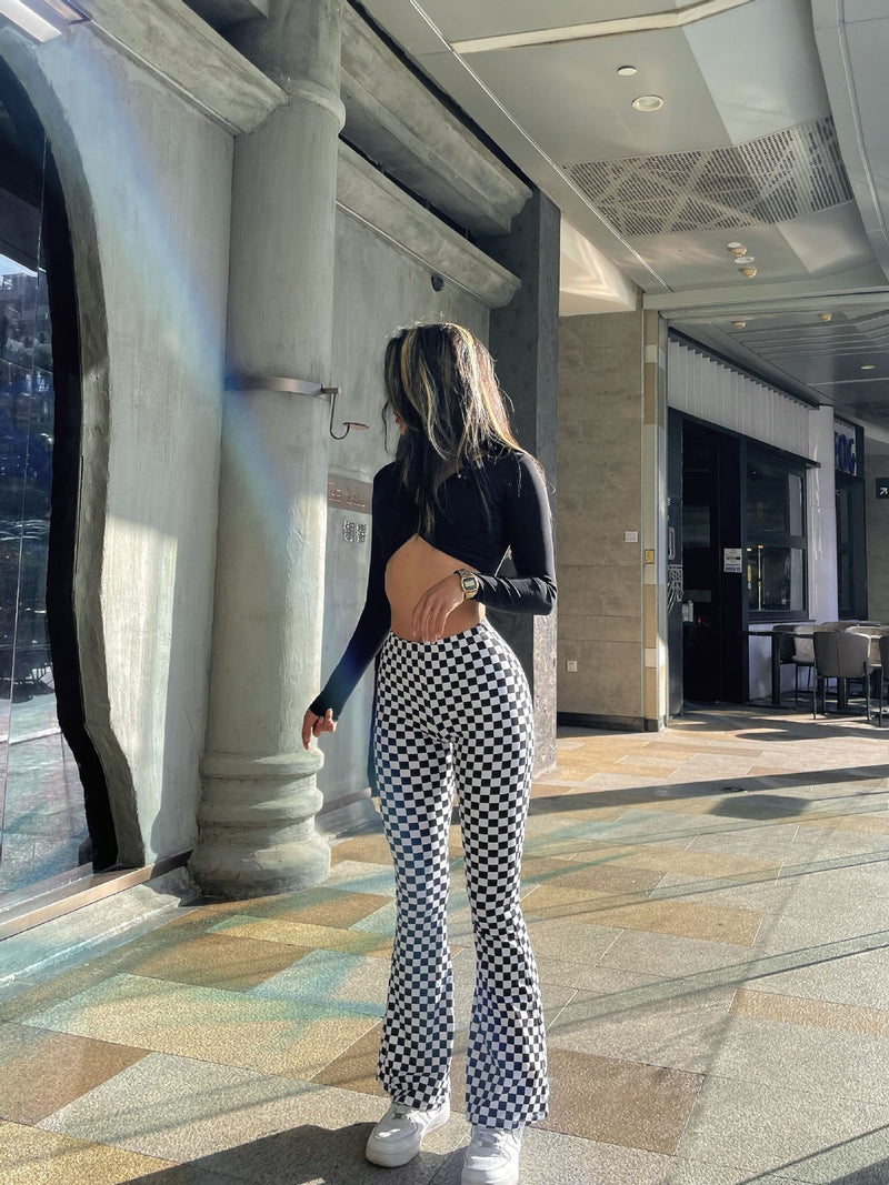 Fashionable black and white plaid yoga bell-bottoms styled with a black top. Ideal for yoga, fitness, or casual streetwear.