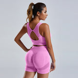 Bright pink women's vest and shorts workout tracksuit with a racerback design. Comfortable and flexible activewear for gym and training.