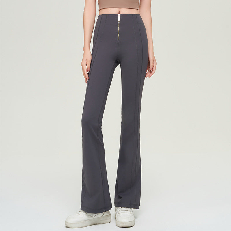 Dark gray high waist slimming trousers with a front zipper, paired with white sneakers. Made of solid color nylon for a sleek look.