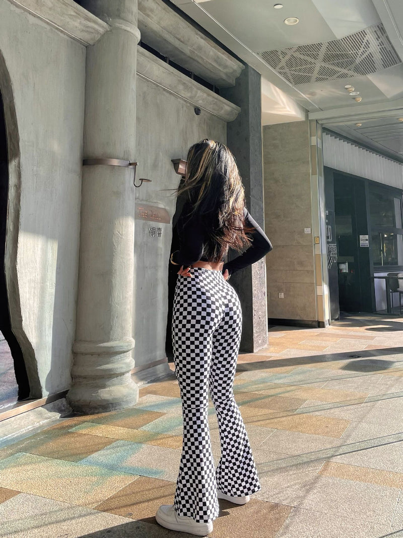 Back view of black and white plaid yoga bell-bottoms, highlighting the snug fit and flared leg design. A fashionable choice for yoga and casual outings.