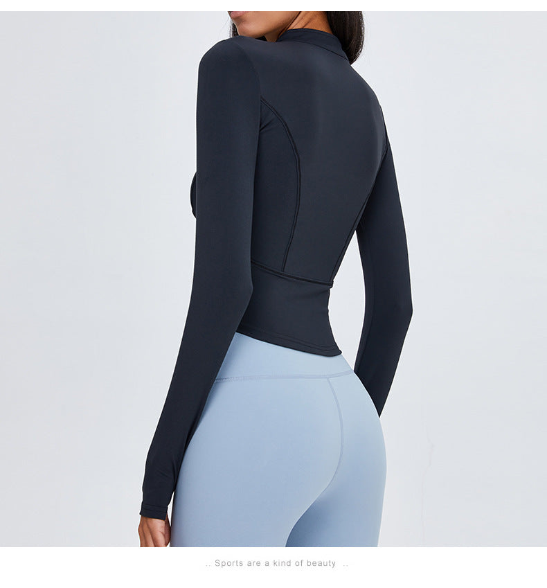 Back view of a black women's yoga sports top with long sleeves. Made from breathable nylon and spandex for a comfortable fit.