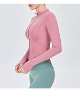 Side view of a pink women's yoga sports top with long sleeves. Made from nylon and spandex for a snug and breathable fit.