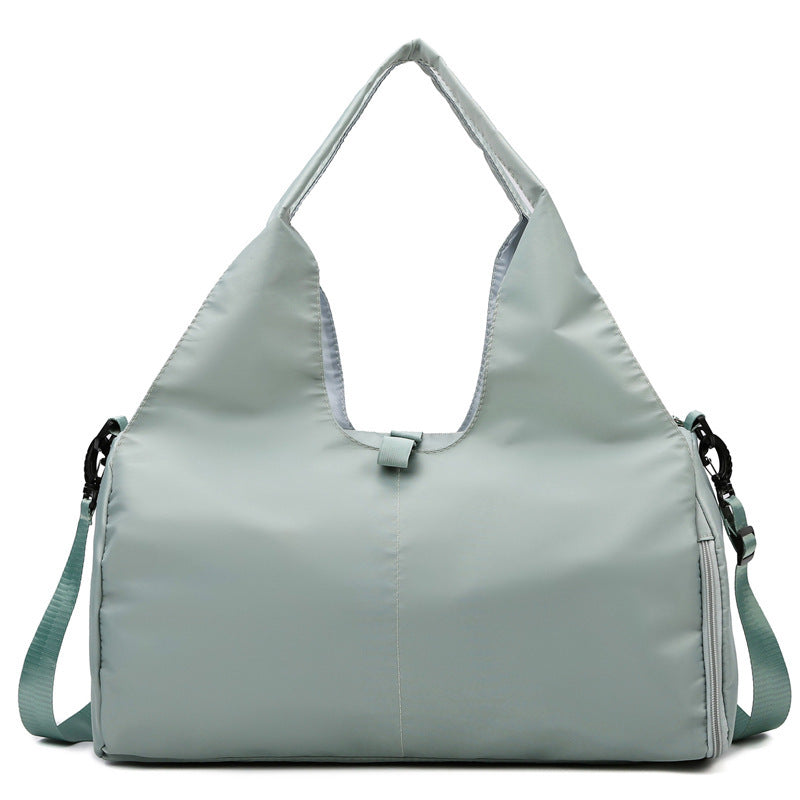 Light green women's large yoga bag with a sleek, water-resistant design, multiple compartments, and sturdy handles for convenience.