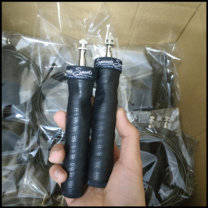 Close-up of black jump rope handles with branding, featuring metal connectors for smooth rotation. Ideal for professional fitness training.