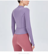 Back view of a purple women's yoga sports top with long sleeves. Designed for flexibility and moisture-wicking performance.