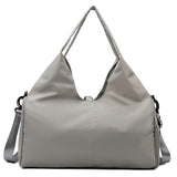 Gray women's large yoga bag with a minimalist design, durable material, and spacious compartments for gym or yoga essentials.