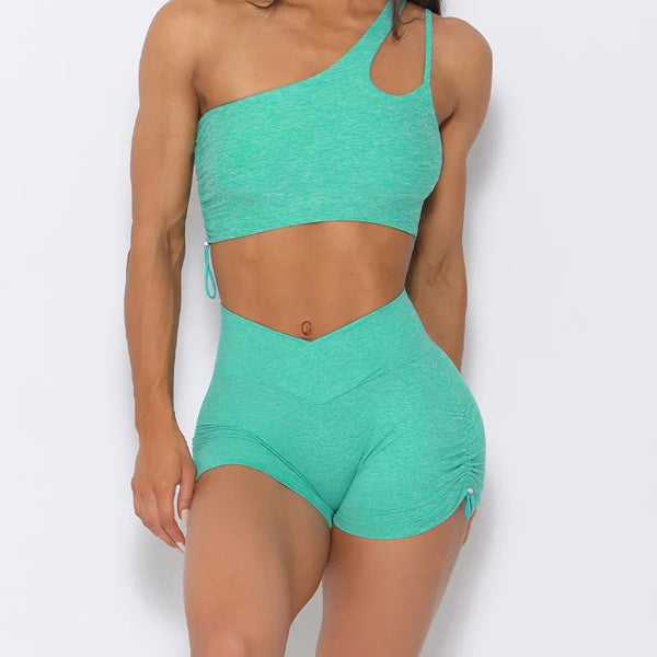 One-shoulder mint green sports bra and ruched shorts set for yoga and fitness. Breathable and stretchy fabric for maximum comfort.