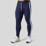 Fitness pants for men made of polyester, featuring a slim fit design with white side stripes. Available in sizes M-XXXL for workout and fitness activities.