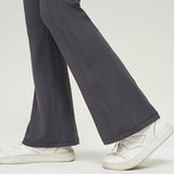 Close-up of dark gray high waist slimming trousers, focusing on the flared leg design. Made of solid color nylon for a fashionable look.