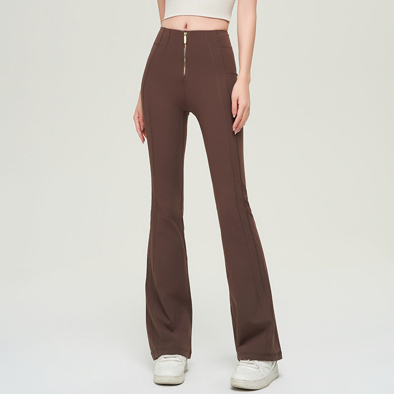 High waist slimming trousers in brown with a front zipper. Made of solid color nylon, these fashion-forward pants offer a flattering fit.